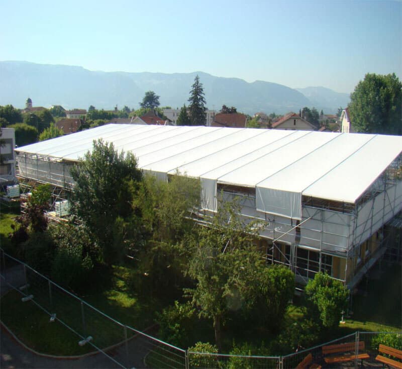 Toiture provisoire blanche posée sur échafaudage au-dessus d'un bâtiment